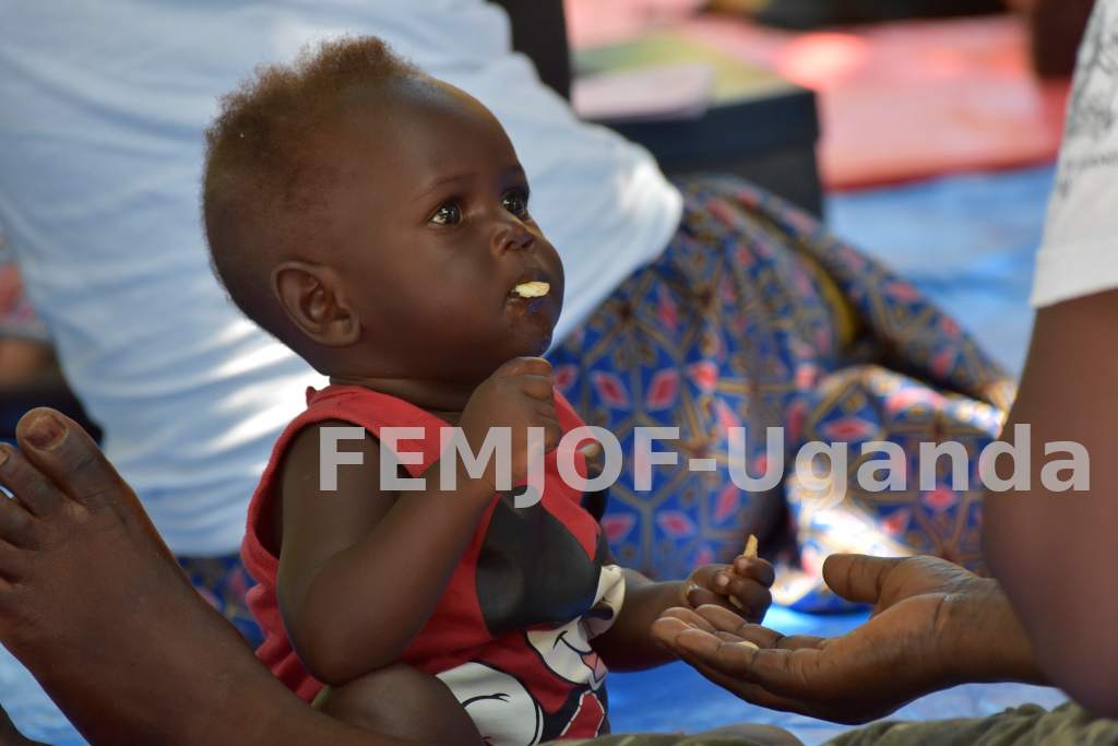 A baby feeds off his mothers hand at Bibi Bidi settlement in Yumbe district on 29th Oct 2021.